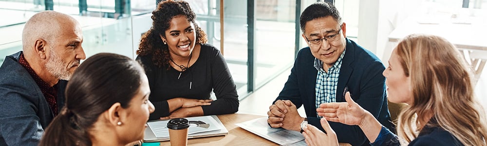 Technology law and policy professionals in a group discussion while sitting at a table