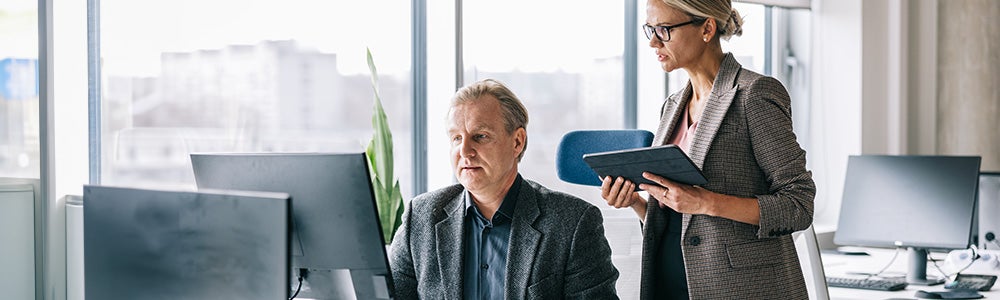 Two colleagues looking at a laptop together